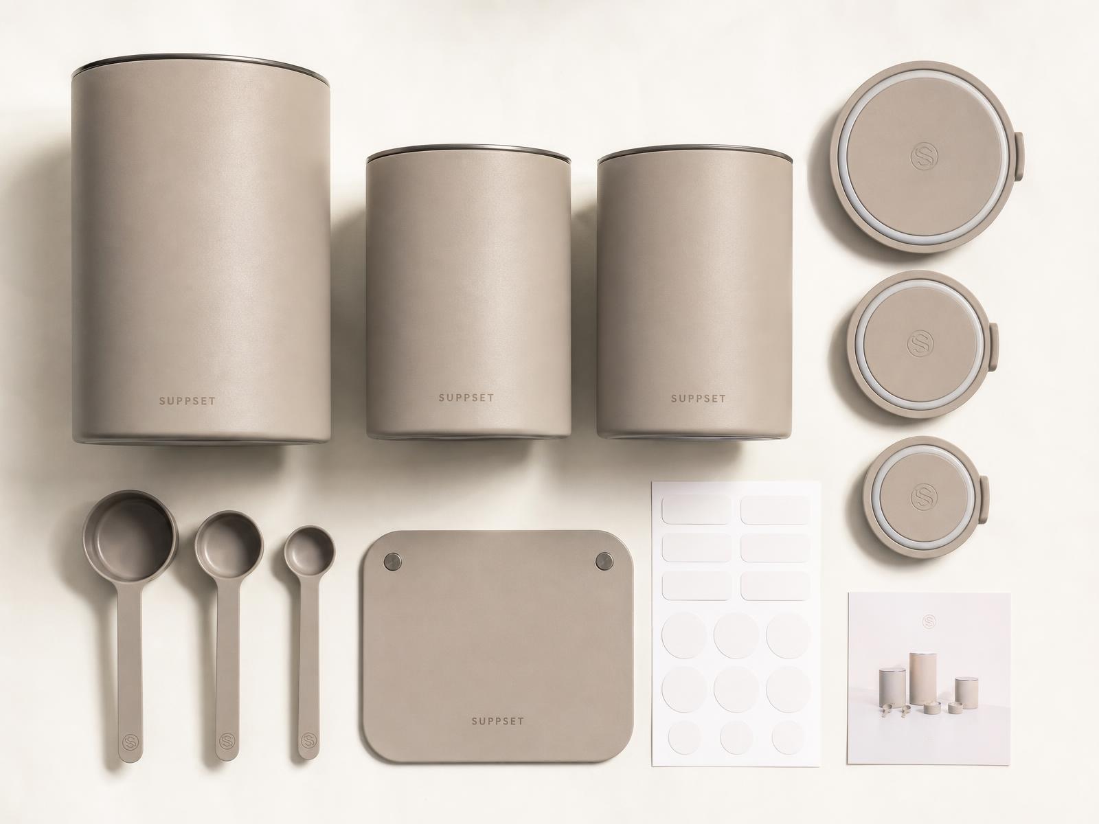 Flatlay of the base, one 2L and two 750ml stainless canisters, three lids, three scoops, label set and routine card